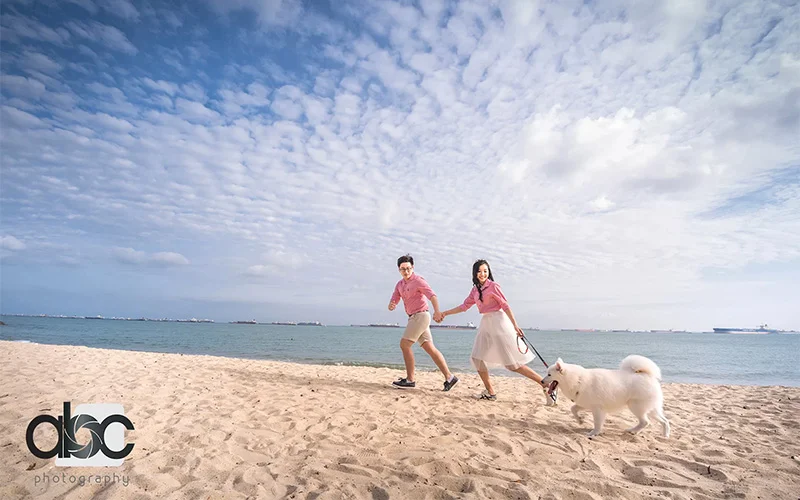 Candid photo of a couple with their dog at the beach